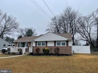 view of front of property with a front lawn, a porch, and fence