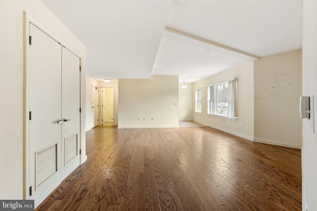 spare room featuring visible vents, baseboards, and wood finished floors