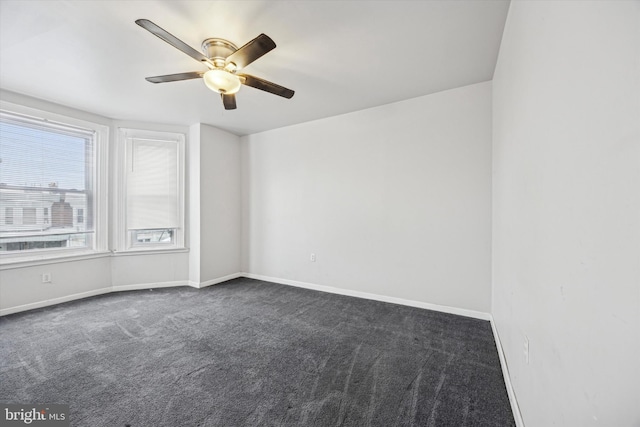 empty room with dark colored carpet and ceiling fan