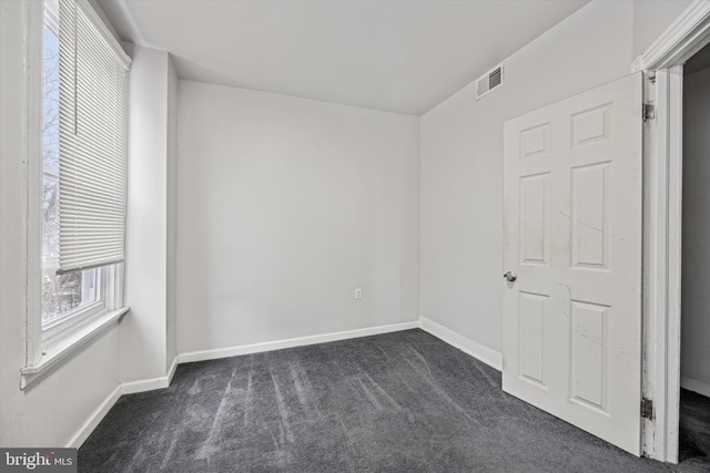 unfurnished bedroom with dark colored carpet