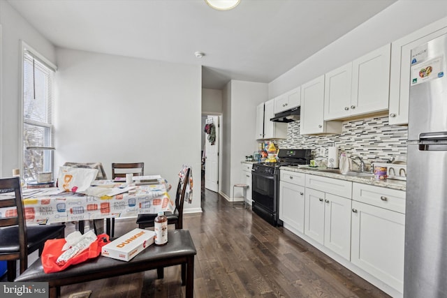 kitchen with white cabinetry, dark hardwood / wood-style floors, light stone countertops, and gas stove