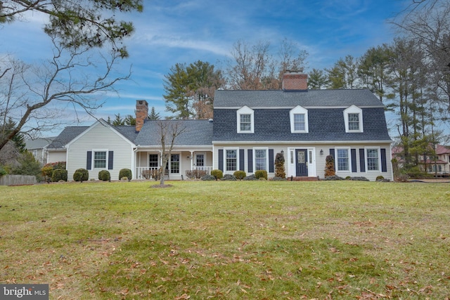 dutch colonial with roof with shingles, a front lawn, a chimney, and a gambrel roof