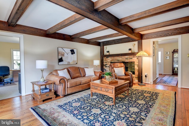 living room featuring wood-type flooring, baseboards, and beamed ceiling