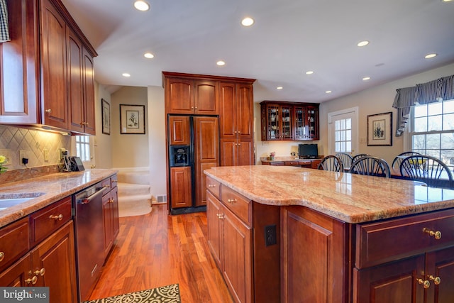 kitchen featuring light wood-style flooring, recessed lighting, paneled built in refrigerator, a center island, and dishwasher