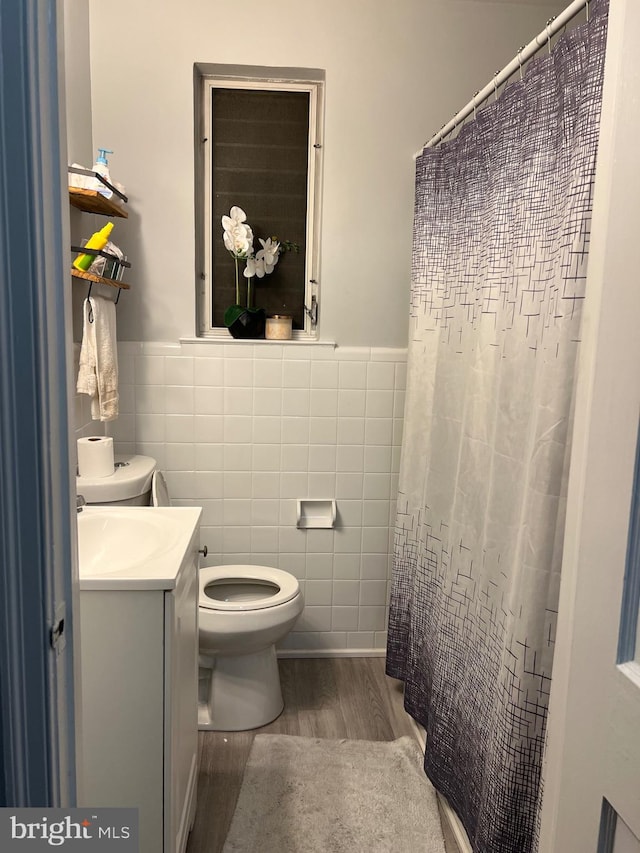 bathroom with vanity, toilet, hardwood / wood-style floors, and tile walls