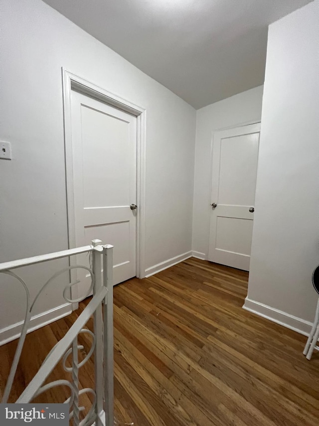 corridor with dark hardwood / wood-style flooring