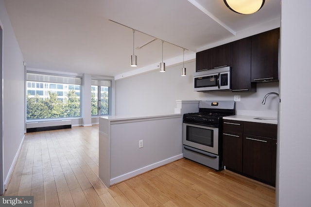 kitchen with sink, light hardwood / wood-style flooring, stainless steel appliances, and kitchen peninsula