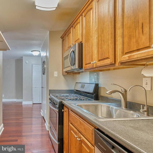 5340 Holmes Run Pkwy Unit 101, Alexandria, VA 22304 - kitchen with appliances with stainless steel finishes, a sink, dark wood-type flooring, and brown cabinets