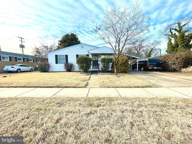 ranch-style house featuring a front lawn and a carport