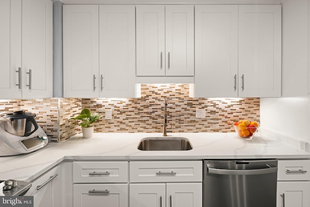 kitchen with a sink, white cabinetry, decorative backsplash, and stainless steel dishwasher