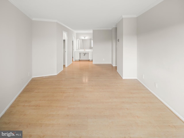 unfurnished living room featuring ornamental molding, light wood-style flooring, and baseboards