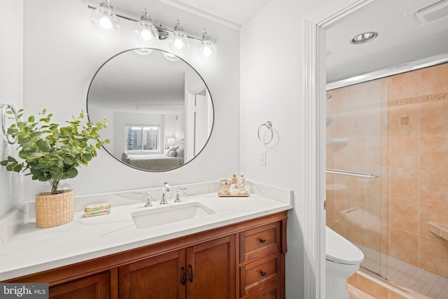 full bath featuring toilet, a stall shower, and vanity