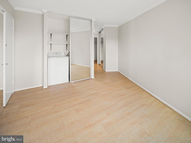 unfurnished bedroom featuring ornamental molding, light wood-type flooring, washer / clothes dryer, and baseboards