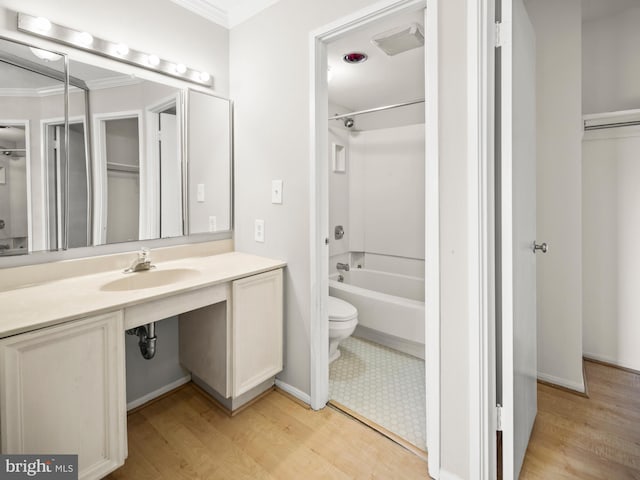 full bath featuring shower / bathtub combination, toilet, wood finished floors, vanity, and ornamental molding