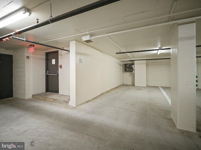 parking deck featuring concrete block wall and a garage door opener