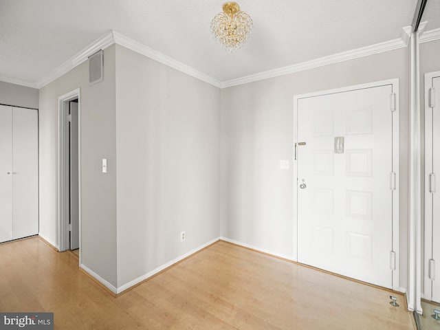 entryway featuring ornamental molding, wood finished floors, visible vents, and baseboards