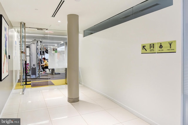 workout area with baseboards and tile patterned floors