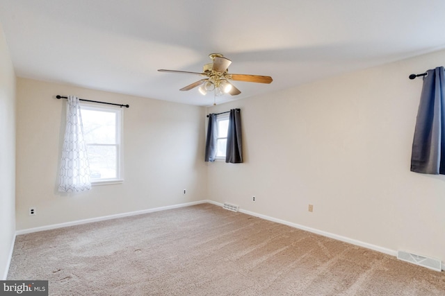 unfurnished room with ceiling fan and carpet