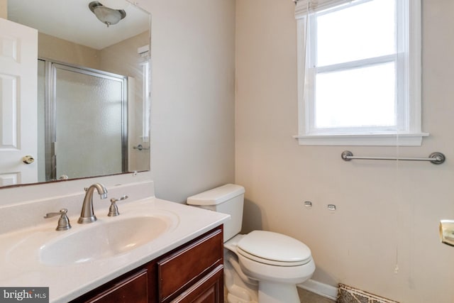 bathroom with vanity, a shower with shower door, toilet, and baseboard heating