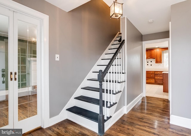 stairway featuring french doors and hardwood / wood-style floors