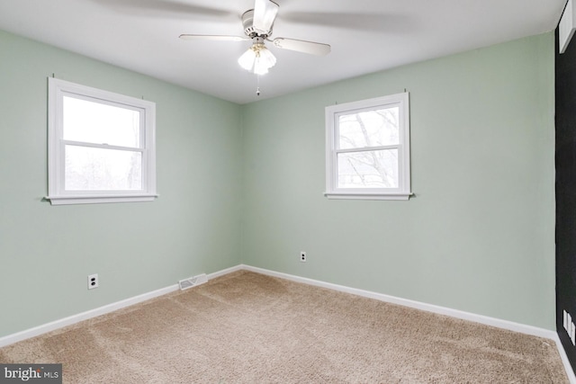 empty room with ceiling fan and carpet floors