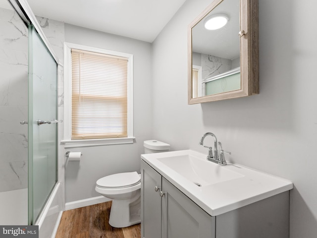 full bathroom with vanity, toilet, hardwood / wood-style floors, and combined bath / shower with glass door