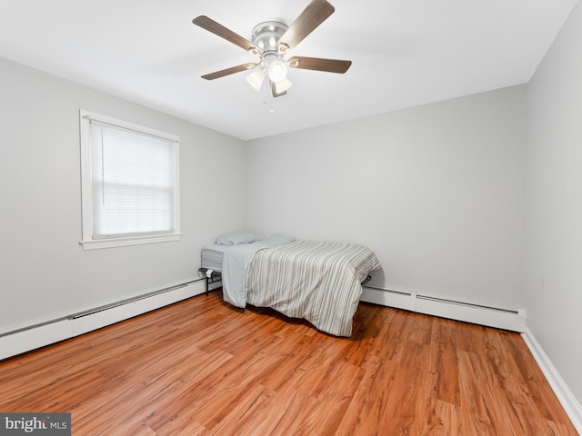 bedroom featuring baseboard heating, ceiling fan, and light hardwood / wood-style flooring