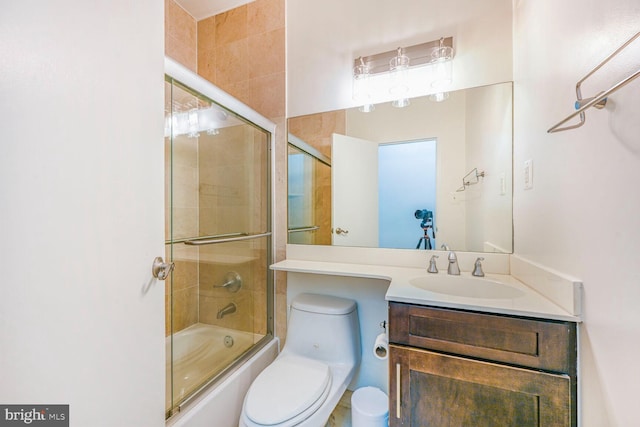 full bathroom featuring vanity, toilet, and combined bath / shower with glass door