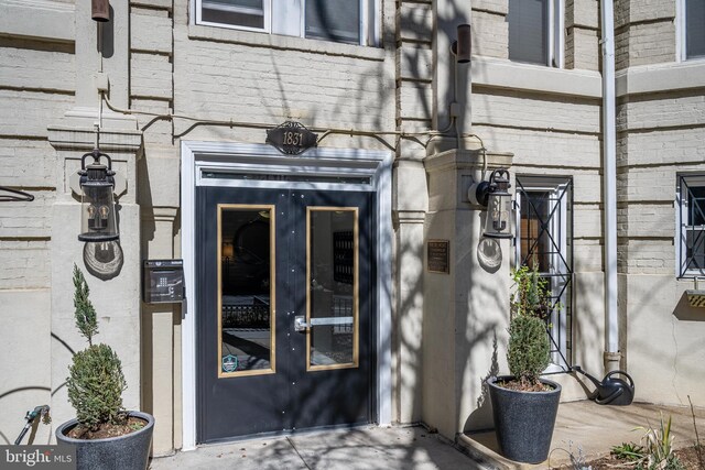 entrance to property featuring brick siding and french doors