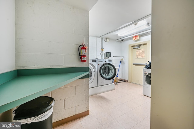 laundry room featuring separate washer and dryer, concrete block wall, and laundry area