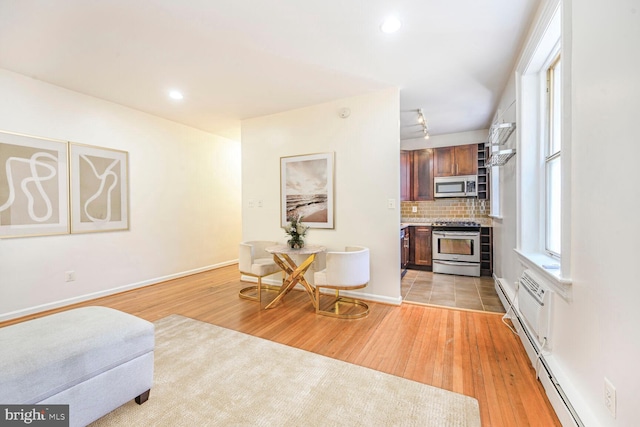 interior space featuring tasteful backsplash, appliances with stainless steel finishes, light countertops, and light wood-style floors