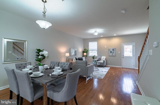 dining area featuring dark wood-type flooring, recessed lighting, stairway, and baseboards