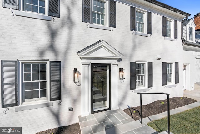 entrance to property featuring brick siding