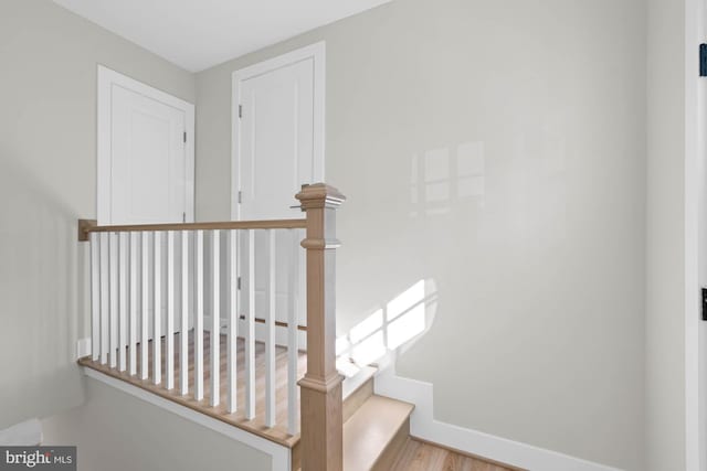 stairway with baseboards and wood finished floors