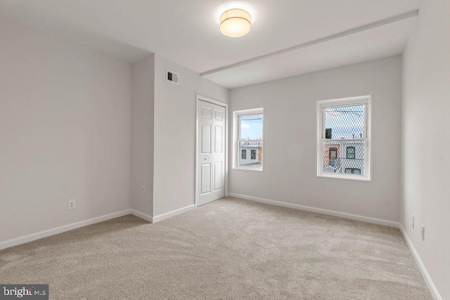 unfurnished bedroom featuring a closet and light carpet