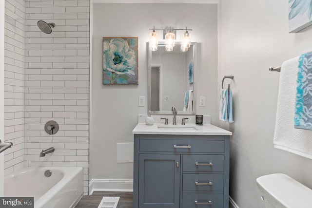 full bathroom featuring vanity, toilet, tiled shower / bath combo, and wood-type flooring