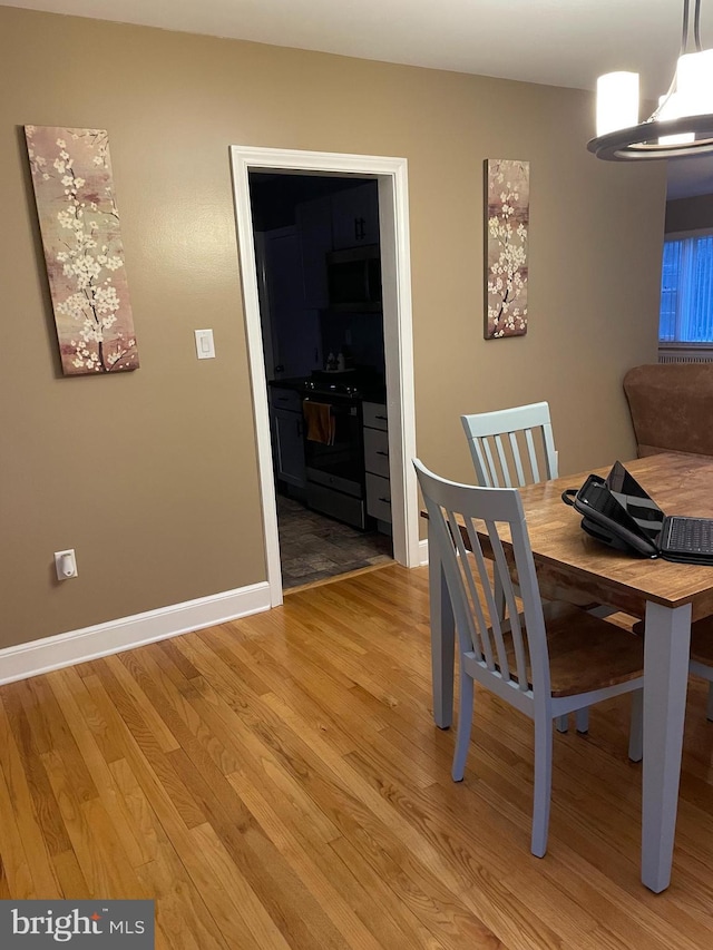 unfurnished dining area with an inviting chandelier and light wood-type flooring