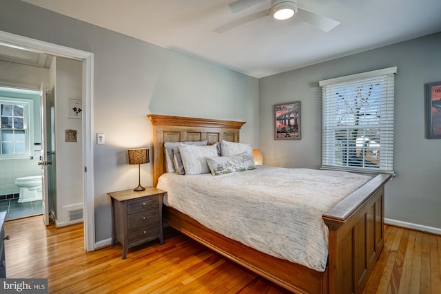 bedroom featuring a ceiling fan, visible vents, light wood-style flooring, and baseboards