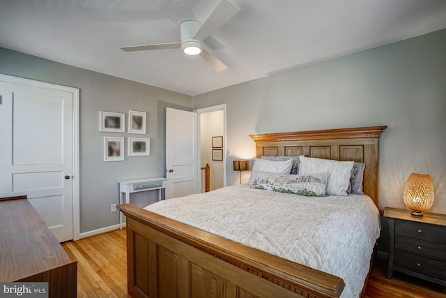 bedroom with light wood-type flooring, baseboards, and a ceiling fan