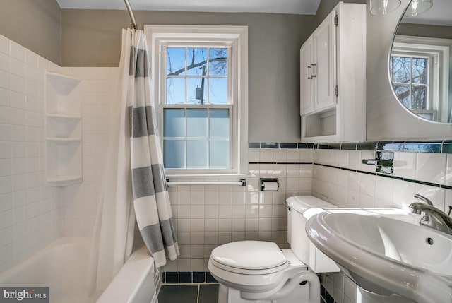 bathroom with toilet, a sink, tile patterned flooring, shower / bathtub combination with curtain, and tile walls