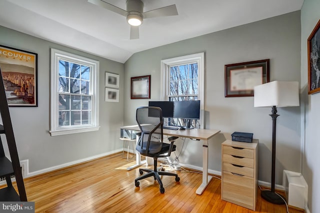 office area with light wood-type flooring, vaulted ceiling, and baseboards