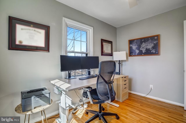 home office with baseboards and wood finished floors