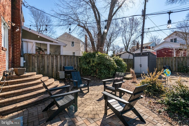 view of patio / terrace featuring a shed, a fenced backyard, and an outbuilding