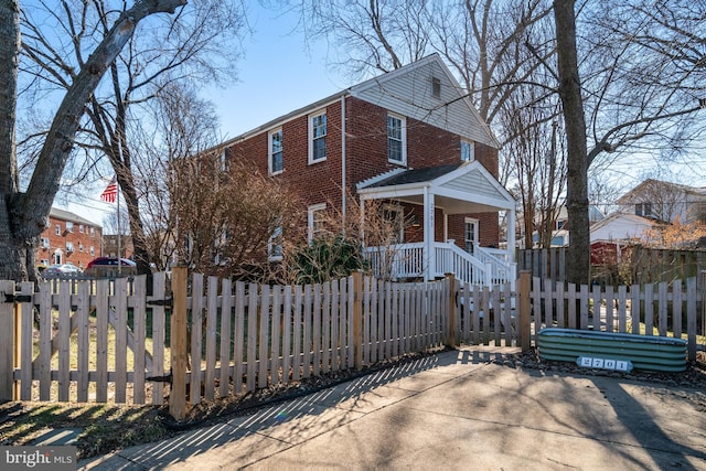 view of front of house with brick siding, a fenced front yard, and a gate