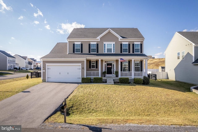 colonial inspired home featuring a porch, a garage, and a front lawn