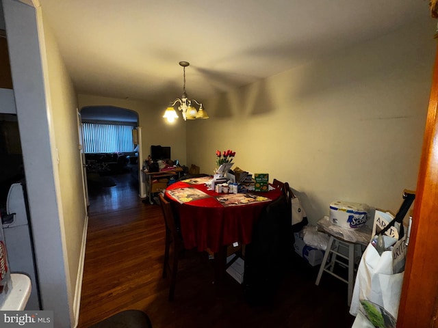 dining area with dark wood-type flooring and a chandelier