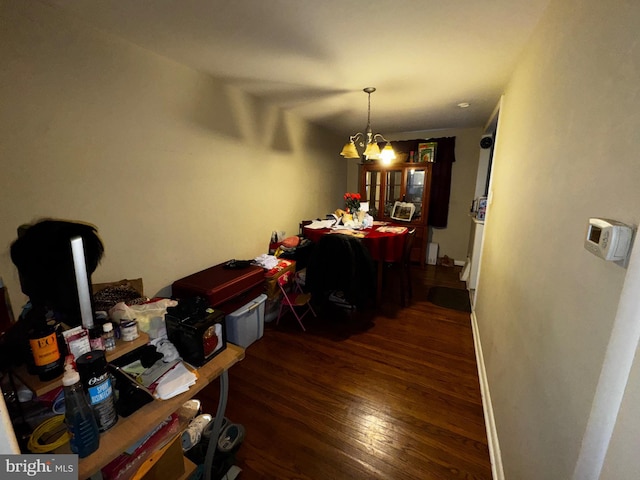 dining area featuring dark hardwood / wood-style flooring and a chandelier