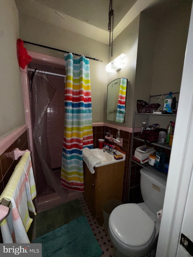 bathroom featuring tile walls, vanity, curtained shower, and toilet