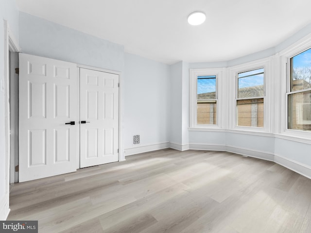 unfurnished bedroom with a closet and light hardwood / wood-style flooring