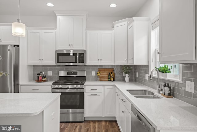 kitchen featuring sink, white cabinets, stainless steel appliances, and pendant lighting